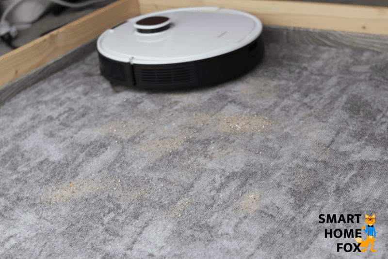Ecovacs Deebot OZMO T8+ vacuums sand on a short pile carpet